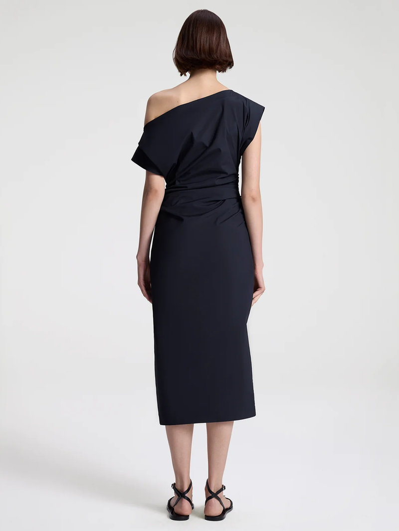 Woman wearing a black one-shoulder dress on a white background