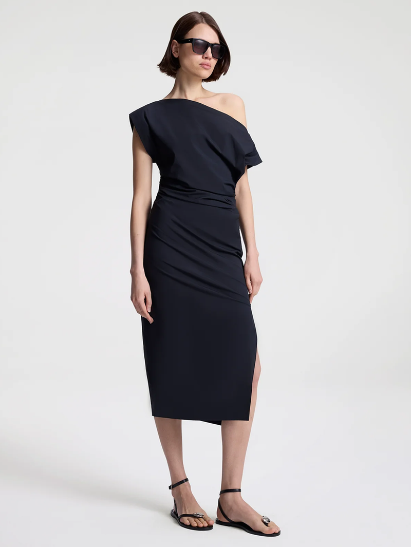 Woman wearing a black one-shoulder dress on a white background