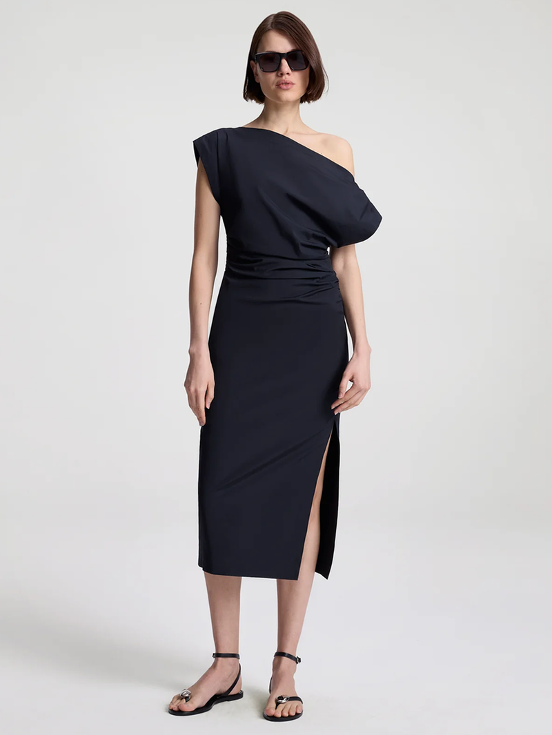 Woman wearing a black one-shoulder dress on a white background
