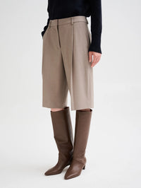 Front view of the Roberto Collina pleated wool Bermuda Pant in Taupe styled with tall brown boots