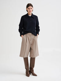 Full length view of the Roberto Collina Bermuda Pant in Taupe with a navy knit polo and boots