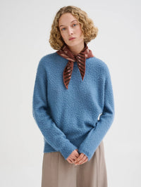 Front view of the Roberto Collina Fair Isle Bandana in Brown knotted over a blue sweater