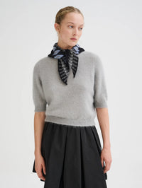Front view of the Roberto Collina Fair Isle Bandana in Grey knotted over a heather sweater