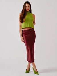 Full length front view of the SABLYN Miranda Silk Skirt in Cabernet with a green knit tank and heels