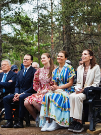 Woman wearing the Riya B Dress in Floral River by SALONI, seated at an outdoor event