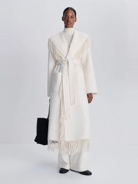 Full-length front view of the SIMKHAI Carrie Fringe Coat in Frost, belted at the waist.