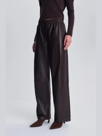 Angled side view of the SIMKHAI Corrine Leather Pant in Dark Chocolate showing the relaxed straight leg