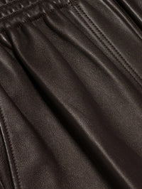 Close up of the elastic waistband and supple lamb leather on the SIMKHAI Corrine Leather Pant in Dark Chocolate