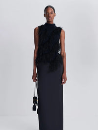 Model in the SIMKHAI Elinor Feather Top in Black, styled with a black column maxi skirt.