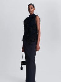 Three-quarter view of the SIMKHAI Elinor Feather Top in Black with a black maxi skirt.