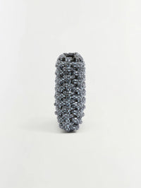 Side profile of the SIMKHAI Morgan Woven Rhinestone Clutch in Black showing its slim depth.