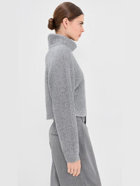 Side view of the SIMKHAI Orlienne turtleneck sweater in Grey Melange showing the cropped length.