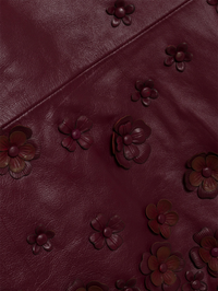 Close-up of embossed floral details on the fig leather Talen Mini Dress by SIMKHAI
