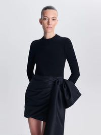Close front view of the knit bodice and taffeta bow on the SIMKHAI Tedda Mini Dress in Black.