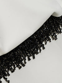 Macro detail of the beaded fringe trim against ivory crepe on the SIMKHAI Vantrel Short Sleeve Gown.