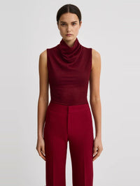 Front view of the SMYTHE Cowl Neck Knit Shell in Garnet with a draped cowl neck, styled with matching trousers