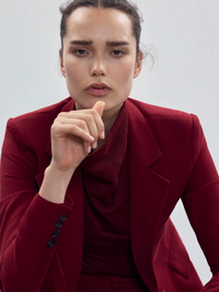 Close-up of the cowl neckline on the Cowl Neck Knit Shell in garnet by SMYTHE, styled under a burgundy blazer