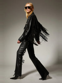 Walking shot of the SPRWMN Black fringe leather micro flare styled with a fringe leather jacket