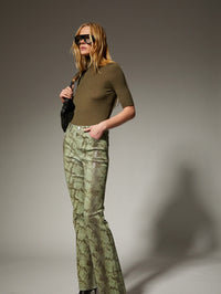 Side view of the SPRWMN Cashmere Turtleneck in Olive with high waisted pants