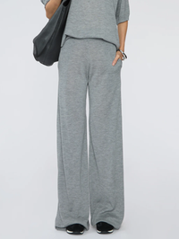 Front view of the Wide Leg Pants in grey by SPRWMN, styled with a matching grey tee and black shoulder bag