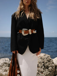 Model wearing the Braun Belt in tan suede over a black blazer and white skirt, Streets Ahead