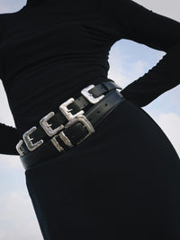 Model wearing the Streets Ahead Multi Silver Buckle Belt in black over a black skirt