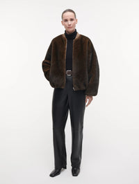 Full length view of the STUDIO AR Etta Faux Fur Bomber Jacket in Olive worn open with leather trousers