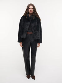 Full length front view of the STUDIO AR Mallow Faux Fur Jacket in Dark Grey worn open over leather trousers