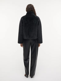 Back view of the STUDIO AR Mallow Cropped Faux Fur Jacket in Dark Grey showing the cropped length