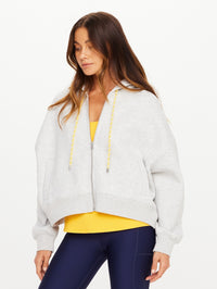 Front view of the Jude Crop Hoodie in grey marle by THE UPSIDE with yellow drawstring