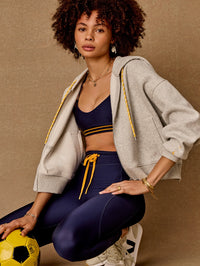 Front view of the Jude Crop Hoodie in grey marle by THE UPSIDE, styled with navy sports set