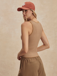 Back view of the Hanson Rib Knit Tank in Mid Tan by VARLEY, styled with a rust baseball cap