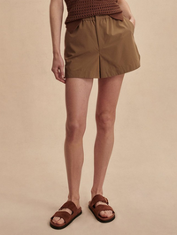 Front view of the Nila Mid Rise Short in Taupe Stone by VARLEY, styled with brown sandals