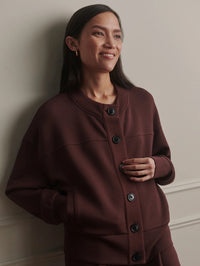 Front view of the Varley Olwen Button Front Sweater in Deep Mahogany on a smiling model