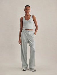 Full-length front view of the Varley Ruby Cropped Tank in Blue Green Marl styled with wide-leg joggers and sneakers