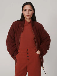 Front view of the Varley Serina Reversible Quilt Jacket in Cherry Mahogany worn open, sherpa side