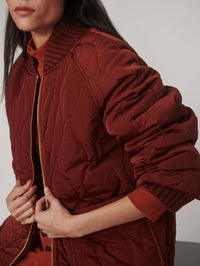 Detail of the quilted crinkle shell on the Varley Serina Reversible Quilt Jacket in Cherry Mahogany