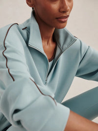 Close-up of the half zip collar and sleeve piping on the Varley Sian Half-Zip Sweat in Tourmaline