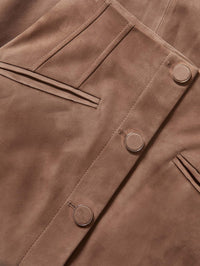 Detail of the covered buttons and angled pocket on the Veronica Beard Callisian Suede Midi Skirt in Bark.