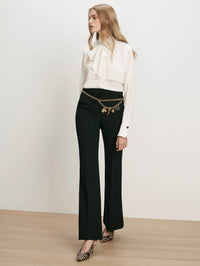 Full length view of the Veronica Beard Darlis Scarf-Neck Blouse in Dove White with black flare trousers.