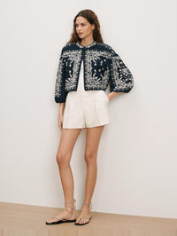 Front view of the Drake Jacket in navy with ornate white embroidery by Veronica Beard, styled with cream shorts