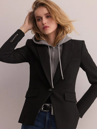 Model in a black blazer layered over the Veronica Beard Oversized Hoodie Dickey in Grey Melange