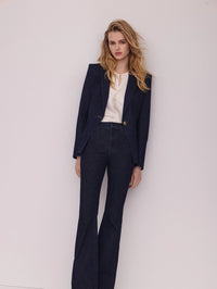 Editorial view of the Veronica Beard Miller Denim Dickey Jacket in Midnight Wash with a silk blouse and flare jeans