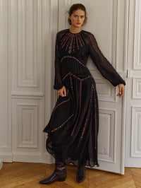 Full-length front view of the Veronica Beard Sylvette Embroidered Maxi Dress in Black with boots