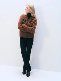 Full-length view of the White & Warren Cashmere Blend Horse Bomber in Umber/Black worn with black jeans.