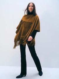 Full length front view of the White + Warren Cashmere Blend Fringe Poncho in Antique Gold with black jeans